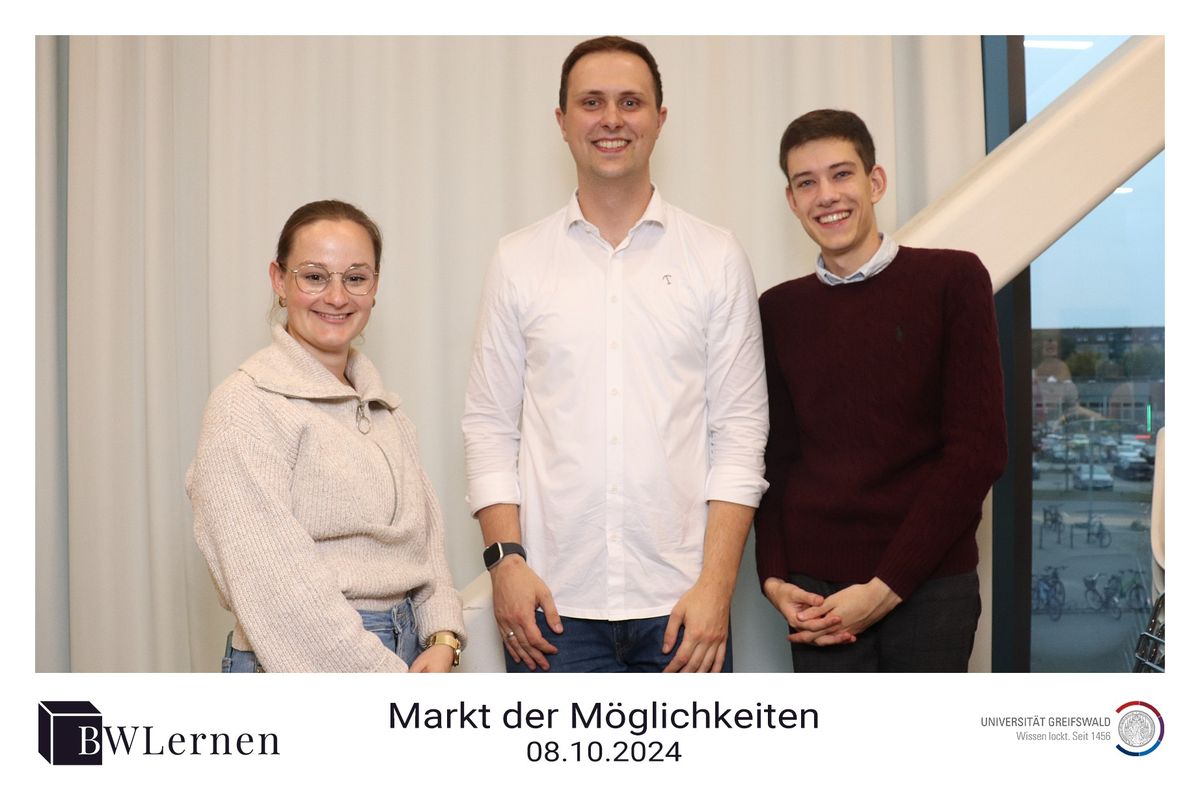 Drei Personen des Projektteams vor einem Vorhang, darunter die Zeile Markt der Möglichkeiten, 08.10.2024